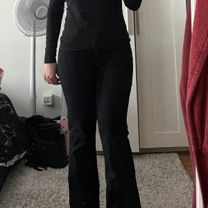 Svarta bootcut byxor - Säljer ett par svarta bootcut byxor med snygg passform och klassisk siluett. Byxorna har normal midja och är tillverkade i ett mjukt material som sitter skönt hela dagen. Perfekta för dig som gillar stilrena och tidlösa plagg.