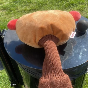 Hotdog head cover - Rolig keps formad som en hotdog med bröd i beige plysch, korv i röd plysch och detaljer i gult och brunt. Märkt med Daphne på sidan. Perfekt för dig som vill sticka ut på golfbanan eller event. Stretchig stickad brun del för bekväm passform.