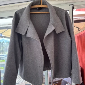 Grå kort kappa  - Snygg grå kappa säljes. Sparsamt använd och i fint skick. Stl M från Gina Tricot. Köpt för något år sedan. Lägg bud om priset är för högt! 