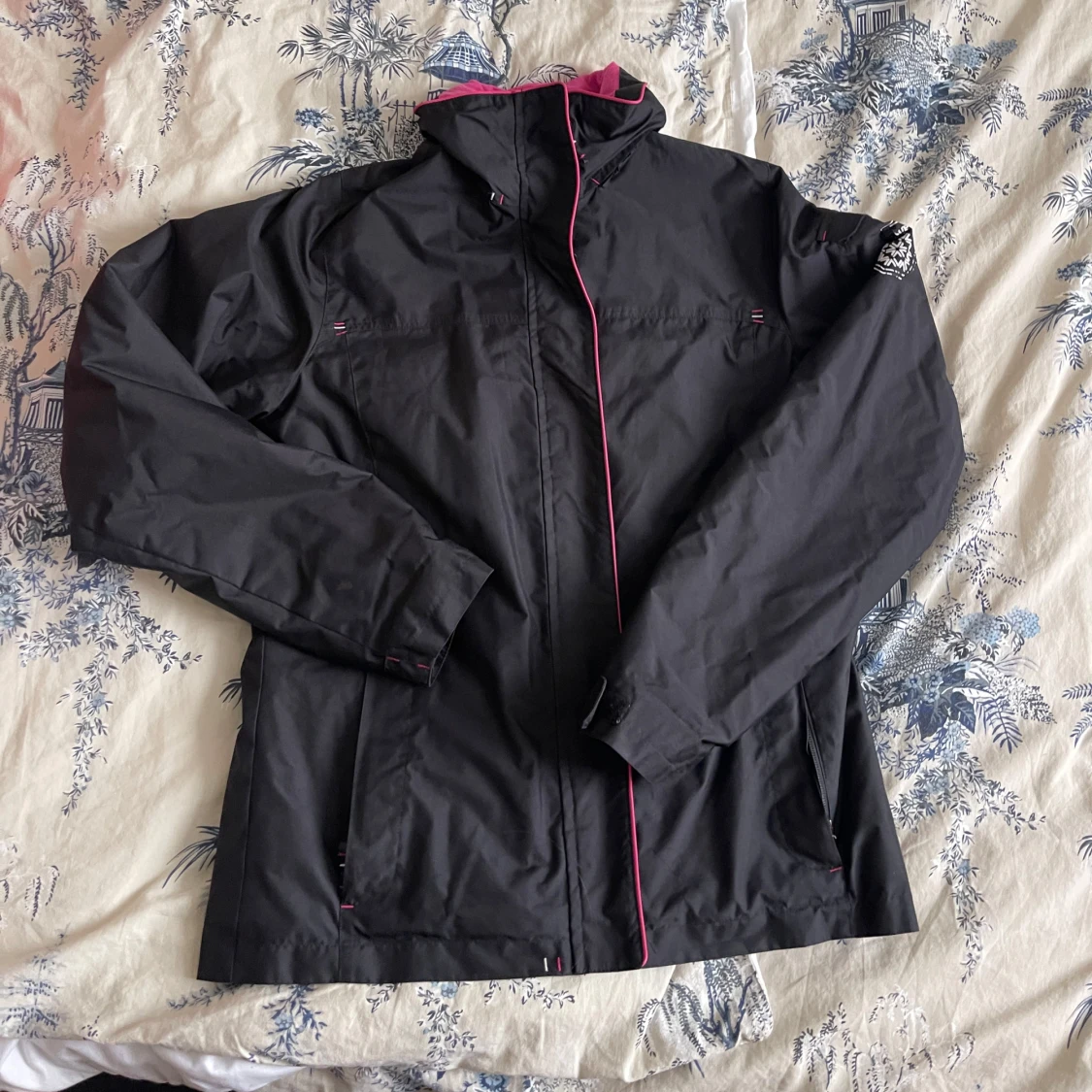 Svart vindjacka med rosa detaljer