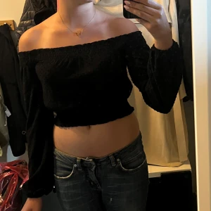 Svart offshoulder croppad topp H&M - Säljer en svart offshoulder topp från H&M Divided i storlek XS. Toppen är croppad med långa puffiga ärmar och smockad resår upptill och nertill. Perfekt för dig som gillar trendiga och stilrena plagg med en twist.