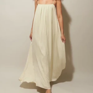 Ljus långklänning med tunna axelband - Säljer en superfin ljus långklänning med tunna axelband och luftig passform. Klänningen har ett mjukt fall och är tillverkad i ett lätt material som känns skönt mot huden. Perfekt för varma dagar och ger en avslappnad, stilren vibe.