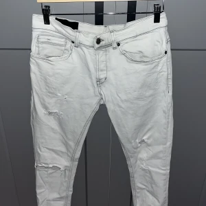 Vita skinny jeans från George, stl 31 - Säljer ett par vita skinny fit jeans från George i storlek 31. Byxorna har klassisk femficksdesign, slitna detaljer på benen och svarta kontrastsömmar. Materialet är mjukt och stretchigt jeans, perfekt för dig som gillar en tajt passform.