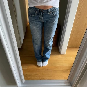 ljusblå jeans straight fit - Klassiska jeans i ljusblå tvätt med raka ben och normal passform. Jeansen har cool fickdetalj på baksidan, är midwaist och snygga slitningar för en avslappnad look. Perfekta till sneakers eller boots och funkar året runt.