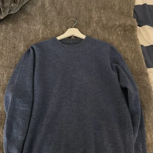 Mörkblå stickad Kashmir tröja med rund hals - En enkel och stilren mörkblå stickad tröja med rund halsringning och långa ärmar. Perfekt för dig som gillar klassiska och bekväma plagg. Tröjan har en mjuk känsla och passar bra till jeans eller chinos. Snygg att bära både till skolan och på stan. Ganska liten i storlek så passar S