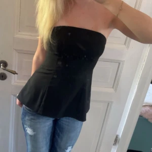 Svart bandeau topp - Snygg svart bandeau tubtopp från Bikbok med utsvängd nederdel och figurnära passform upptill. Toppen är axelbandslös och har en stilren, enkel design som är lätt att matcha med jeans eller kjol. Perfekt för dig som gillar minimalistisk stil💗Aldrig kommit till använding, prislapp kvar
