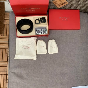 Ferragamo bälte - Snyggt svart bälte från Salvatore Ferragamo med präglat mönster och två utbytbara spännen, ett i matt svart och ett i blankt silver. Bältet är tillverkat i exklusivt skinn och levereras i originalförpackning med dustbags. Perfekt för dig som vill ha en.  lyxig 💰 accessoar. För flera frågor och funderingar skicka ett sms 💬 