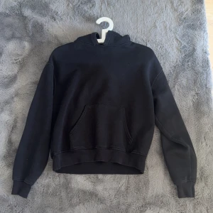Svart hoodie med huva och ficka - super bra till mycke tillfällen.
