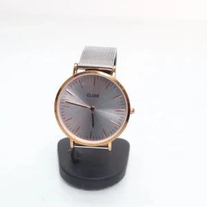 CLUSE silverfärgad meshklocka - Stilren klocka från CLUSE med rund urtavla i silver och detaljer i roséguld. Armbandet är i mesh och har en snygg, modern känsla. Perfekt accessoar för dig som gillar minimalistisk design och metalliska toner.           Behöver ett nytt batteri.