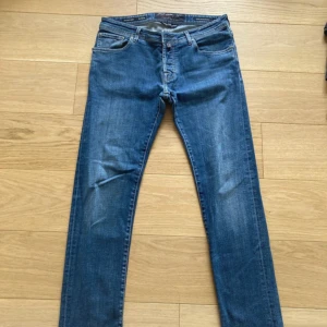 Blå jeans från Jacob Cohën, W33 - Snygga blå jeans från Jacob Cohën i klassisk femficksmodell. Jeansen har raka ben, normal passform och är tillverkade i mjukt bomullsjeans. Fina detaljer som märkets logga på insidan och metallknapp framtill. Perfekta för en stilren och avslappnad look.