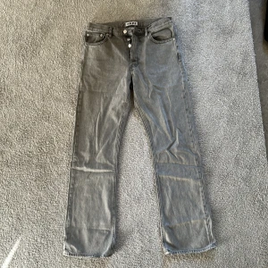 Grå jeans från HOPE Stockholm - Säljer ett par grå jeans från HOPE Stockholm, modell rush denim. Materialet är robust denim och färgen är en snygg, lite urtvättad grå ton. Perfekta till en avslappnad och stilren look. Defekter: hål i höger ficka, går lätt att sy ihop (bild 4).