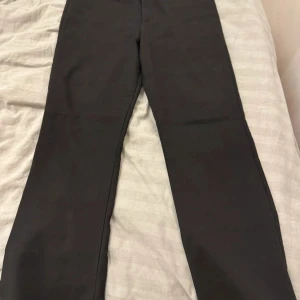 Svarta bootcut byxor från Zara - Svarta bootcut byxor från Zara i storlek M. Byxorna har hög midja och är tillverkade i ett stretchigt material som sitter snyggt och bekvämt. Perfekta för dig som gillar en stilren look med lite utsvängda ben.