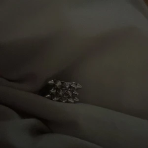 Silvrig ring med nitar - Cool ring i silverfärgad metall med rektangulär form och flera små nitar på ovansidan. Perfekt accessoar för dig som gillar edgy och unik stil. Från Edblad pris kan diskuteras 