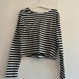 Randig långärmad tröja svart/vit M - Snygg långärmad tröja med svarta och vita horisontella ränder. Tröjan har en klassisk rund halsringning och är i en normal passform. Perfekt till jeans eller kjol för en chill och stilren look.