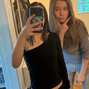 Svart oneshoulder topp från RYVLS - Säljer en svart långärmad topp från RYVLS med snygg oneshoulder-design. Toppen är croppad och har en stilren, enkel look som passar perfekt till jeans eller kjol. Mjuk och skön bomullskvalitet, riktigt nice passform för dig som gillar trendiga detaljer.