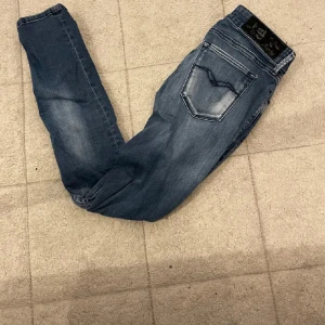 Blå Replay skinny jeans - Snygga blå skinny jeans från Replay med slitningar och ljusa partier framtill. Klassisk femficksmodell med normal midja och dragkedja. Perfekta för dig som gillar en tajt passform och vill ha ett par jeans som sticker ut lite extra.små i storlekarna