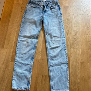  ljusblå jeans straight fit med låg midja från Gina Tricot  - Ljusblå klassiska jeans med rak passform, femficksdesign och låg midja. Jeansen har en ikonisk knappgylf och är tillverkade i slitstarkt bomullsjeans. 
