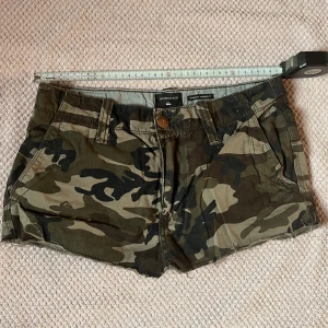 Lowwaist mini shorts - Lågmidjade camo shorts. Storleken uppskattas vara ungefär XS/S. Dom har klippts och sytts kortare och är därför inte helt perfekta men dom ser mycket bra ut på!