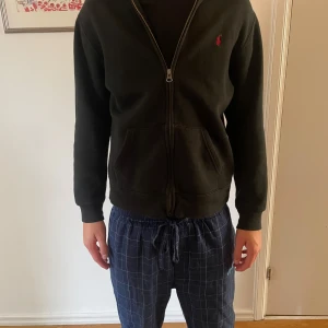 Ralph lauren hoodie - Svart hoodie med dragkedja från Ralph Lauren med röd logga. Storlek 14-16, men passar XS. Inga tecken på skador. Kom privat för frågor. Pris går att diskutera vid snabb affär!