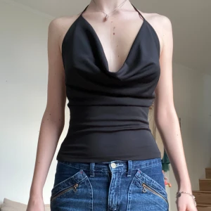 Gina Tricot topp - Svart halterneck topp från Gina Tricot. Storlek XS. Aldrig använd, lappen är kvar. Säljer då den aldrig kom till användning. Ord. pris 299kr.