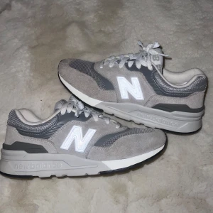 Grå New Balance sneakers - Gråa New Balance sneakers. Ovandel i mocka och mesh, vita snören och reflekterande N-logga på sidan. Sparsamt använda. 🩶🩶