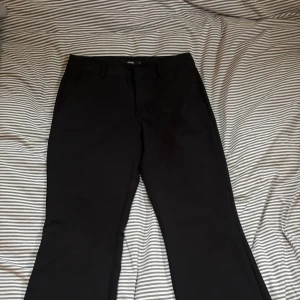 Lågmidjade kostymbyxor från BikBok  - Svarta kostymbyxor från BikBok i klassisk rak modell. Detta är den gamla modellen utan slitt som inte säljs längre. Dom är i bra skick och använda fåtal gånger