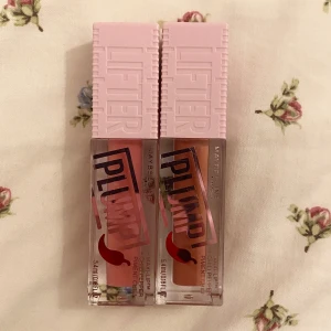 Maybelline Lip Plump läppglans duo - Två Maybelline Lifter Plump läppglans. Ena är i en varm nude-brun nyans och den andra i en mjuk rosa.. Perfekt för att få fylliga och glansiga läppar. Ordinarie pris 160kr/styck, mitt pris båda för 176kr💕