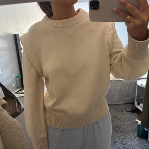Beige stickad tröja med axeldetalj - Säljer en beige stickad tröja från Other stories. Köpte den för 990kr och använt den en gång, helt som ny!! Tröjan är i storlek L men sitter som en M på mig👌