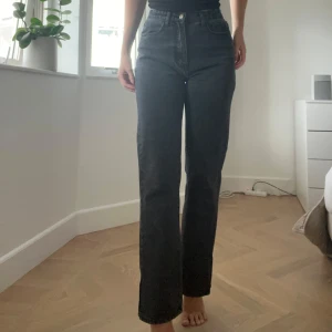 Svarta raka jeans med hög midja och slits - Snygga svarta jeans med rak passform, hög midja och slits. Använd max 5 gånger, säljer då det är lite korta för mig som är 174