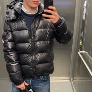 Svart maya jacka från Moncler - Snygg svart Moncler jacka i modellen ”maya” i bra skick! 8/10. En klassisk pufferdesign som ger både stil och värme. Jackan är från GARMSMARKET i storlek 2/M.  Hör av er vid frågor, bilder mm. Pris kan diskuteras så inte hugget i sten. Sjävklart äkta! 