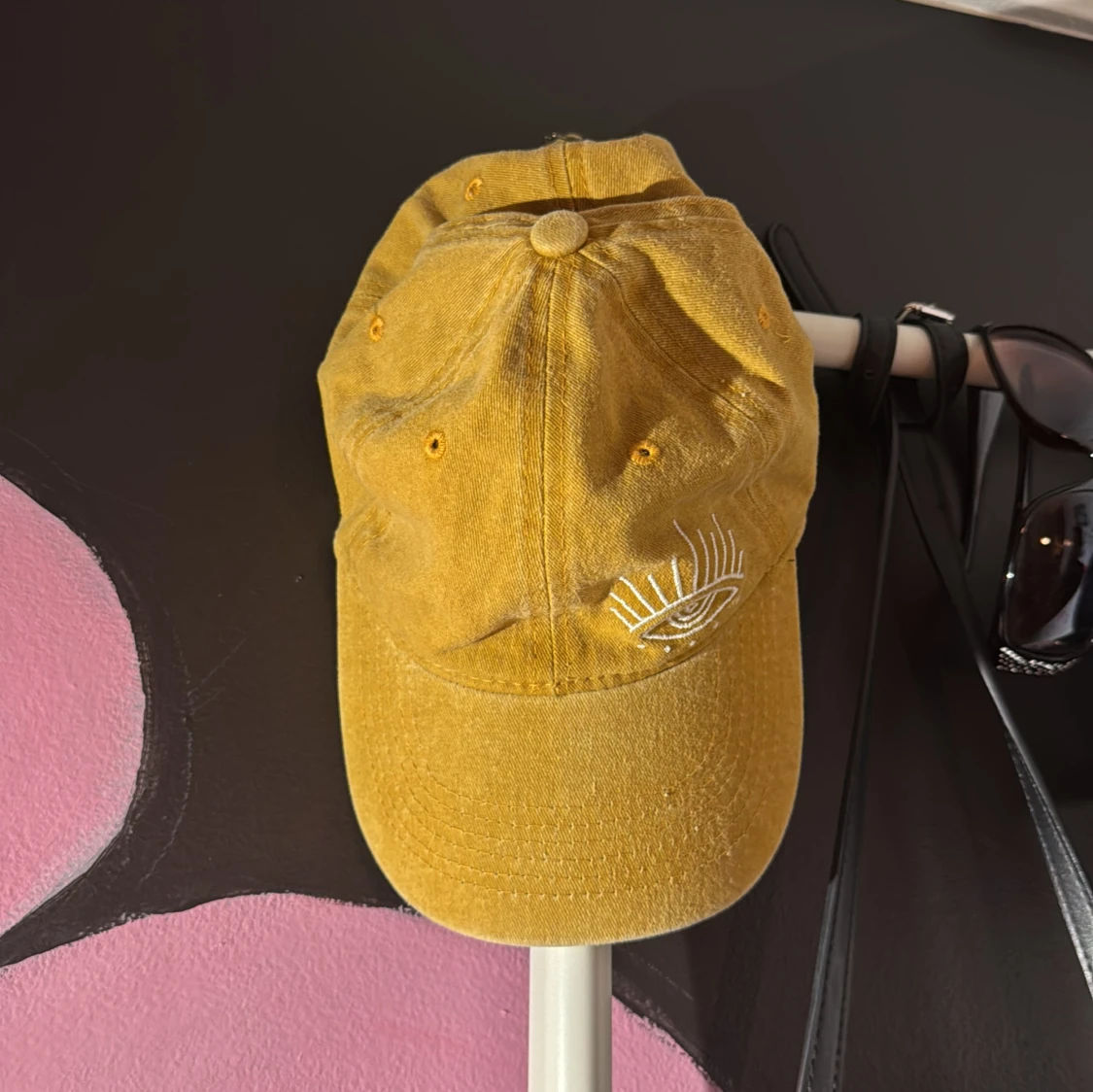 Gul keps med broderat öga