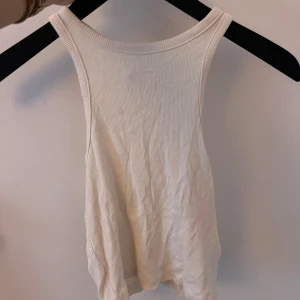 Vit ribbad linnetopp - Säljer en stilren vit ribbad linnetopp med breda axelband. Från H&M.