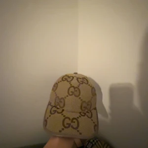 Beige keps med GG-mönster - Snygg beige keps med det ikoniska GG-mönstret. Perfekt för att ge din outfit en lyxig touch. Kepsen har en klassisk design med böjd skärm och justerbar passform.