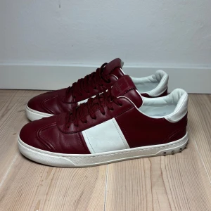 Valentino flycrew vinröda storlek 43/44 - Snygga sneakers från Valentino i rött och vitt skinn. Skorna har en klassisk design med snörning och en vit sula. Perfekta för en stilren look. Storlek 43 men passar 44 alla nitar finns kvar och skorna har inga defekter alls mer än lite använda. Priset går att diskutera vid snabb affär.