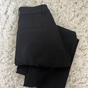 Svarta kostymbyxor - Svarta kostymbyxor med rak passform från Gina Tricot. Väldigt sparsamt använda. Jag är  174 cm och de är  lite korta på mig. Skriv för fler bilder så skickar jag så snabbt som möjligt!
