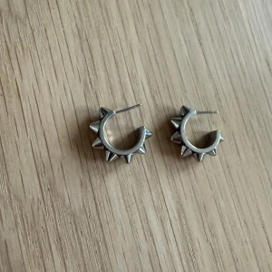 Silvriga örhängen med nitar från Edblad  - Snygga silvriga örhängen i form av ringar med coola nitar runtom. Perfekta för att ge din outfit en edgy touch. Passar både till vardag och speciella tillfällen. Kommer tyvärr inte längre till användning därför säljer jag dom !💓Väldigt fint skick! Skicka till mig ifall ni vill ha fler bilder eller ifall ni har frågor!💓
