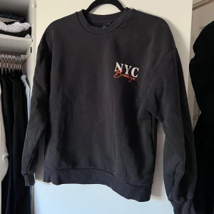 Mörkgrå sweatshirt från Gina Tricot - Säljer en mörkgrå sweatshirt från Gina Tricot med tryck på både framsidan ochbaksidan. Tröjan har långa ärmar och en rund halsringning. Perfekt för en avslappnad stil. 🖤 Önskar du veta exakta mått? Tveka inte att höra av dig!