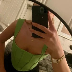 Grön korsett med snörning - Snygg grön korsett med breda axelband och snörning i ryggen. Passar bra till både jeans och kjol. Används inte längre