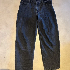 Svarta baggy jeans från Levi's - Säljer ett par svarta baggy jeans från Levi's Premium. De har en klassisk femficksdesign och är tillverkade i slitstarkt denim. Perfekta för en avslappnad stil.