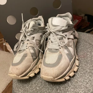 Grå sneakers från Ash - Säljer ett par grå sneakers från Ash med snörning och robust sula. Skorna har en modern design med olika grå nyanser och detaljer i syntetmaterial. Perfekta för en sportig look. Orginal priset 2130