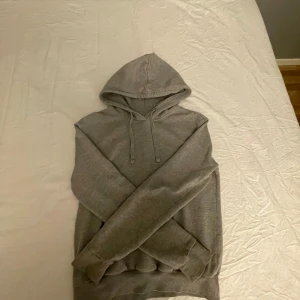 Grå hoodie - Säljer en grå hoodie med snörning och ficka i fram. 