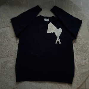 Mörkblå tröja från Ami - Säljer en stilren mörkblå tröja från Ami med ett vitt hjärta och bokstaven A på bröstet. Tröjan har långa ärmar och en klassisk passform. Perfekt för en trendig look.