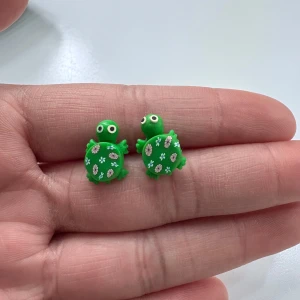 Gröna sköldpaddsörhängen med blommor - Supergulliga örhängen formade som gröna sköldpaddor med vita blommor på skalet. Perfekta för att ge din stil en lekfull och unik touch!