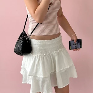 Vit volangkjol med smock i midjan - Säljer en söt vit kjol med volanger och smockad midja. Kjolen har två lager med volangkant och är perfekt för en somrig look. Lätt och luftig modell som passar till många olika toppar. Inköpt på raglady för 499kr.