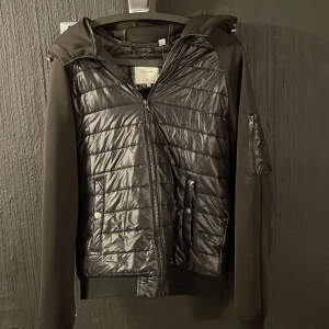 Svart Jack & Jones Cardigan - Säljer en riktigt snygg och stilren svart cardigan från Jack & Jones. Jackan är i mycket bra skick och bara sparsamt använd – ser i princip ny ut!  Den har en modern design med detaljer i både tyg och quiltat material. Perfekt för både vardag och lite finare tillfällen.  Nypris över 2000 kr – mitt pris: 950 kr! ÖPPEN FÖR PRISFÖRSLAG - SKRIV GÄRNA Storlek: L (passar även M) Skick: Nästan som ny  Hör av dig om du har frågor eller vill ha fler bilder!