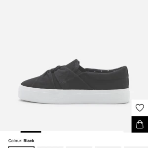 Svarta slip-on sandaler från Anna Field - Svarta slip-on sandaler från Anna Field med knutdetalj framtill. Skorna har en platt sula och är tillverkade i textilmaterial. Perfekta för varmare dagar och enkla att ta på sig. Använt 2-3 gånger 