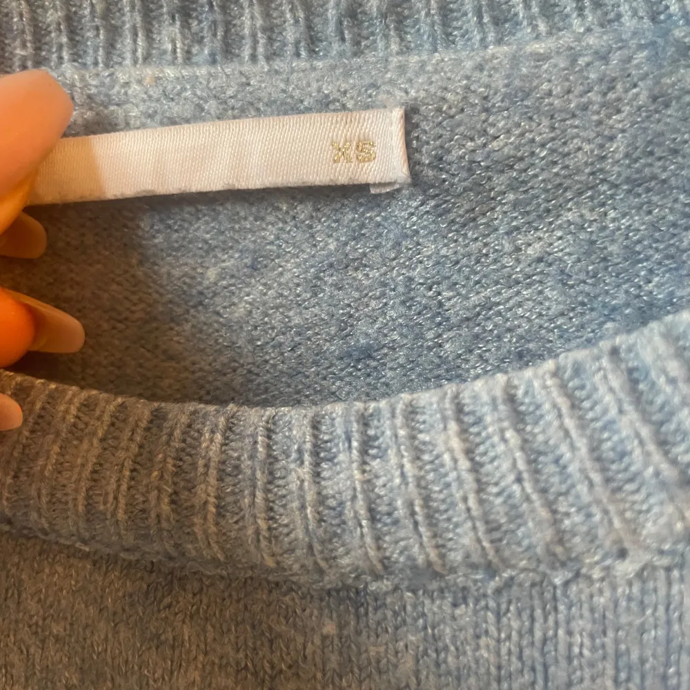 Mysig ljusblå stickad tröja från ONLY med rund halsringning och ribbade muddar vid ärmslut och nederkant. Perfekt för lager-på-lager och enkel att matcha med jeans eller kjol. Tröjan är väl använd så den har lite små anmärkningar . Neuletakit & Villapaidat.