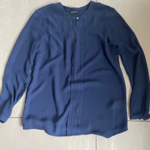Blus/skjorta - Jag säljer en mörkblå skjorta/blus med silvriga knappar som detaljer. 