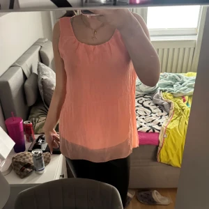 Ljusrosa ärmlös linnetopp - Säljer en ljusrosa, luftig och ärmlös linnetopp med rund halsringning. Perfekt för varma dagar och enkel att matcha med olika outfits.