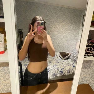 Brun ribbad linnetopp från Divided - Säljer en brun ribbad linnetopp från Divided. Toppen är ärmlös och har en tight passform, perfekt för varma dagar eller som layering-piece. Enkel och stilren design som passar till mycket.